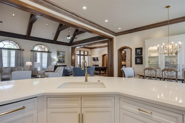 kitchen featuring ceiling fan, white cabinetry, sink, and decorative light fixtures