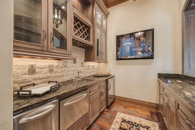 kitchen with backsplash, stainless steel dishwasher, dark stone counters, dark wood-type flooring, and sink