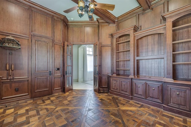 unfurnished office with dark parquet floors, ceiling fan, ornamental molding, and wood walls