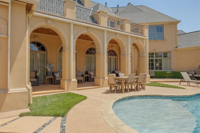 back of property with a balcony and a patio