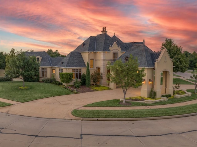 french country home featuring a lawn