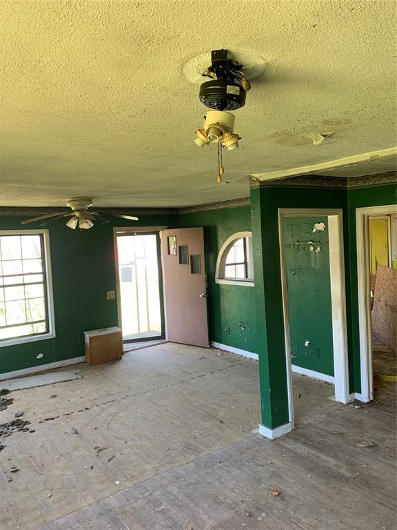 unfurnished room with plenty of natural light, ceiling fan, and a textured ceiling