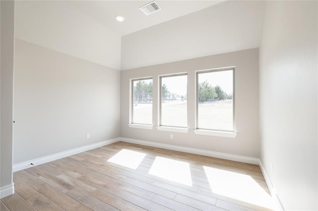 spare room featuring light wood finished floors, baseboards, and visible vents