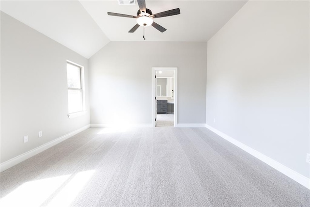 spare room featuring baseboards, visible vents, lofted ceiling, light colored carpet, and ceiling fan