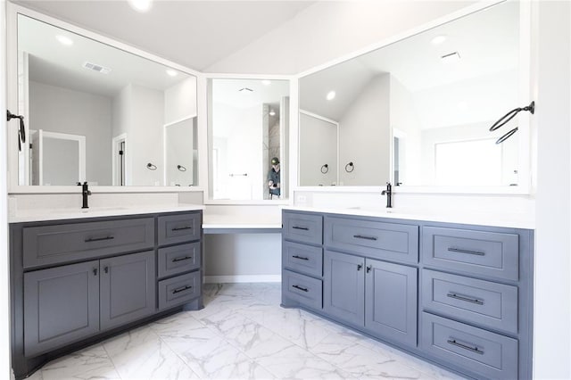 bathroom featuring visible vents, a sink, vaulted ceiling, two vanities, and marble finish floor