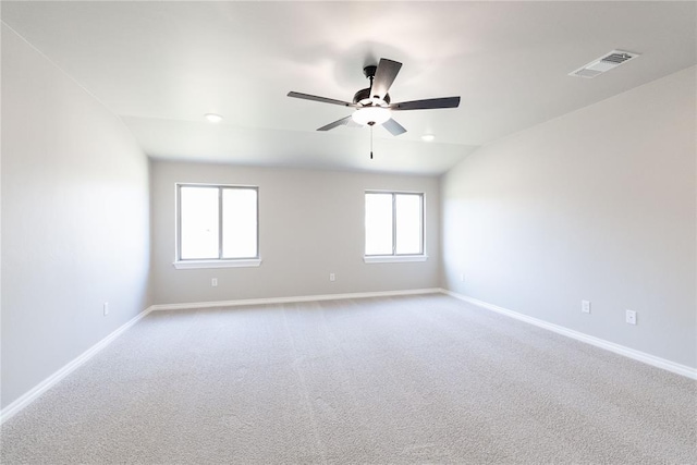 carpeted empty room with visible vents, baseboards, and a ceiling fan