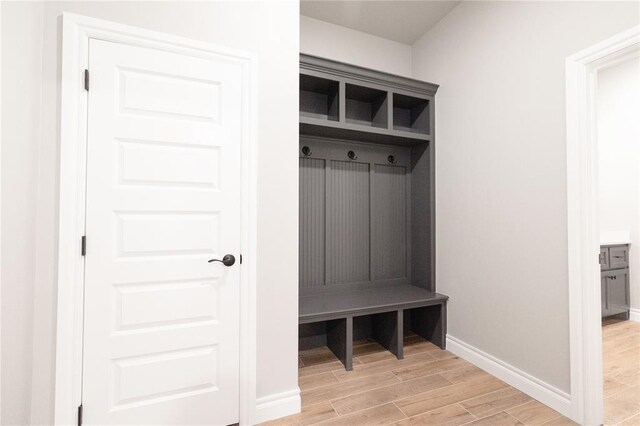 mudroom featuring light wood-style flooring and baseboards