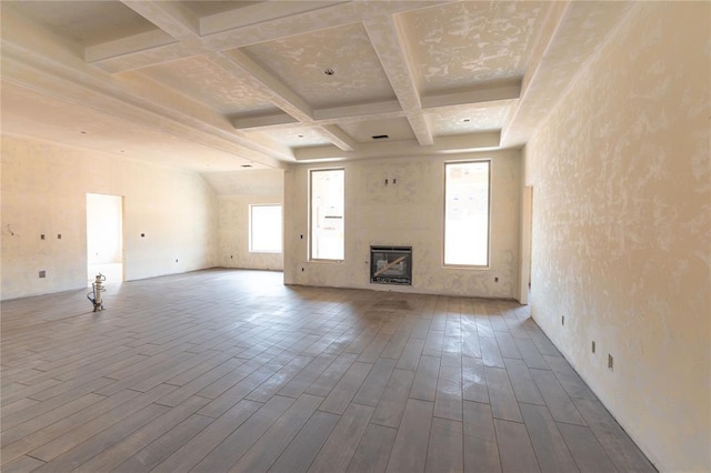 unfurnished living room featuring beam ceiling and coffered ceiling