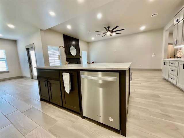 kitchen featuring a kitchen island with sink, ceiling fan, sink, dishwasher, and white cabinets