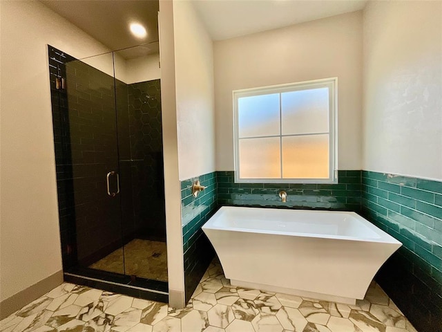 bathroom featuring separate shower and tub and tile walls