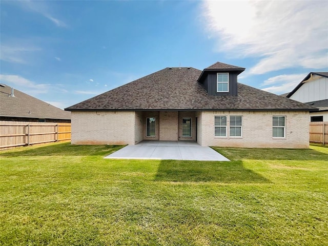 back of house with a lawn and a patio