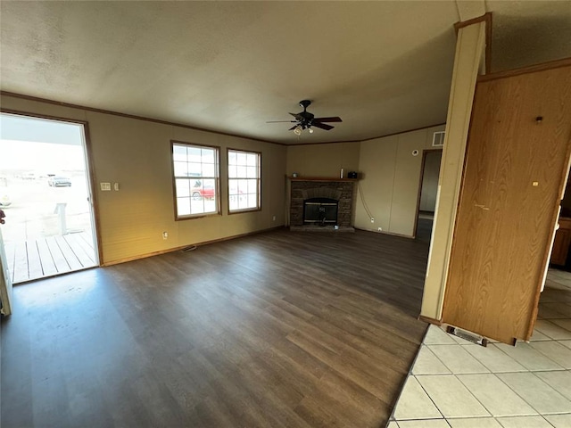 unfurnished living room featuring ceiling fan, light hardwood / wood-style flooring, and a brick fireplace