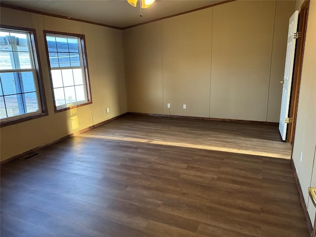 empty room featuring dark hardwood / wood-style floors and ornamental molding