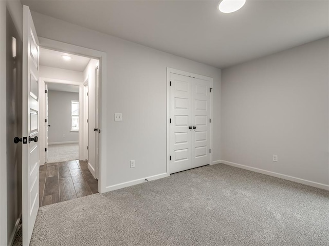 unfurnished bedroom featuring a closet and dark colored carpet