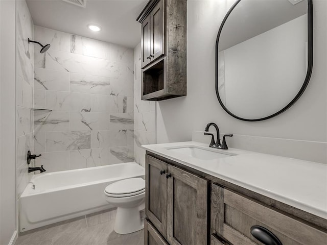 full bathroom featuring tiled shower / bath, vanity, and toilet