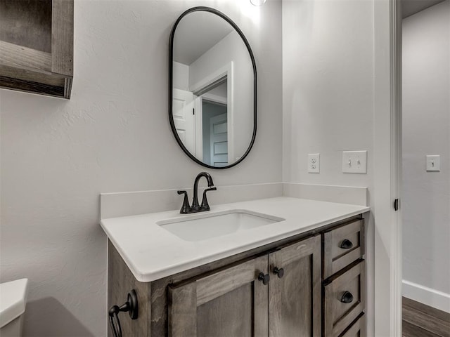 bathroom with vanity, toilet, and wood-type flooring