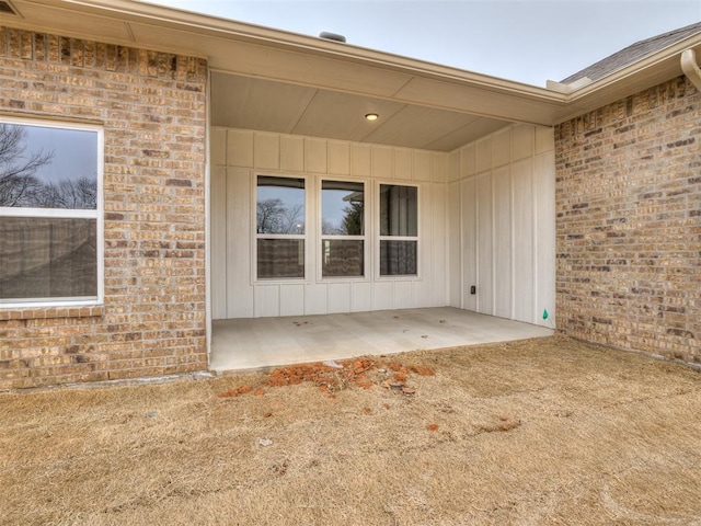 view of exterior entry with a patio