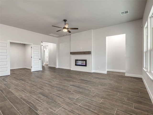 unfurnished living room featuring ceiling fan and dark hardwood / wood-style floors