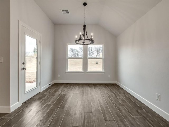 unfurnished dining area featuring dark hardwood / wood-style flooring, vaulted ceiling, and an inviting chandelier