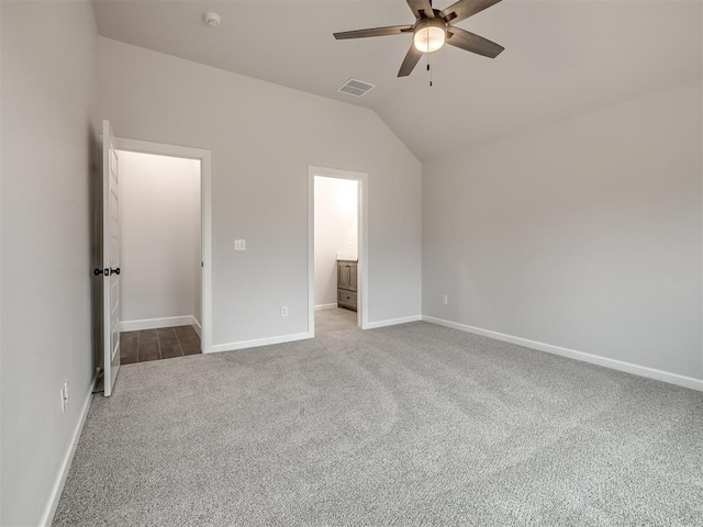 unfurnished bedroom with lofted ceiling, carpet floors, ceiling fan, and ensuite bathroom