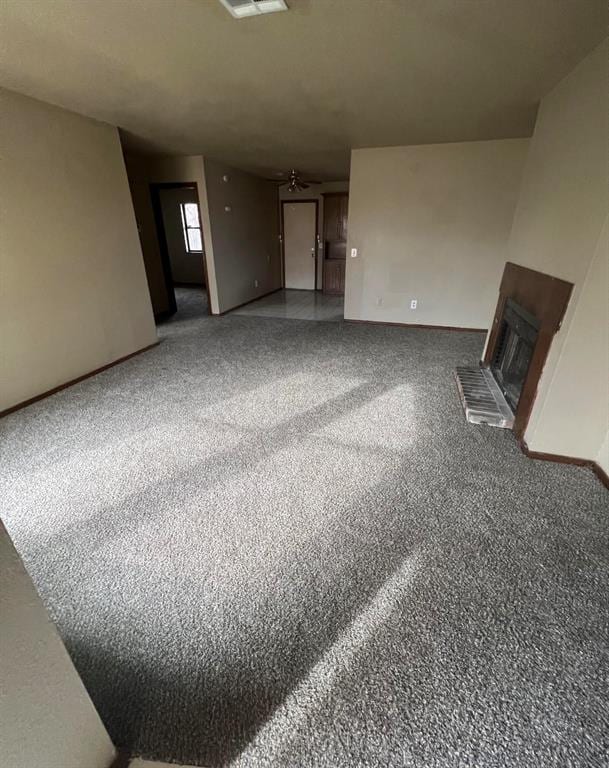 unfurnished living room with ceiling fan and carpet floors