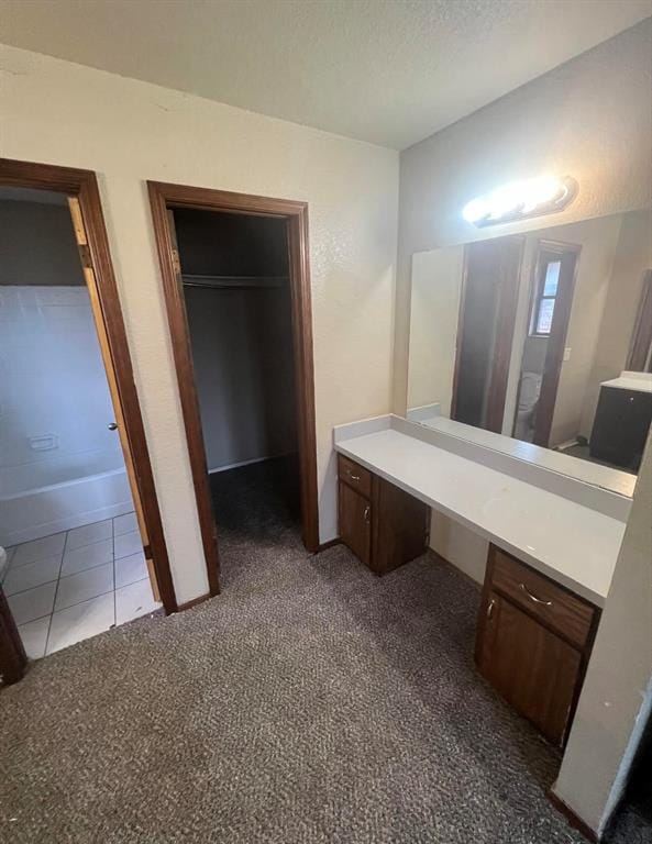 bathroom with tile patterned floors, a bathtub, a textured ceiling, vanity, and toilet