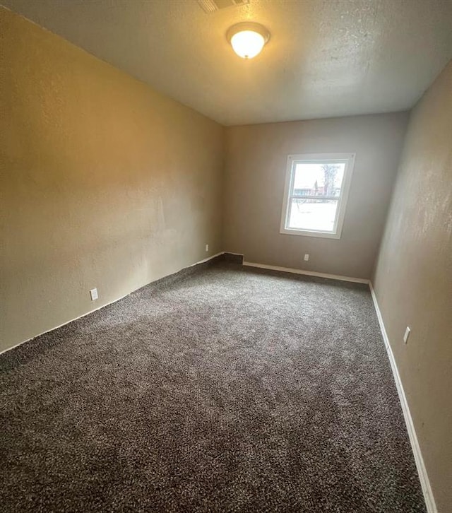 carpeted empty room featuring a textured ceiling