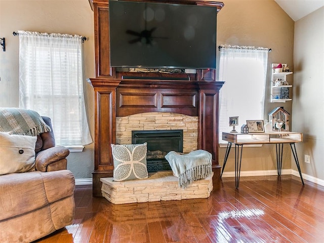 sitting room featuring a fireplace, lofted ceiling, and dark wood-type flooring