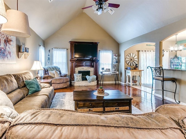 3393 Creek View Ct, Newcastle, OK 73065 - living area featuring a ceiling fan, wood finished floors, a fireplace, high vaulted ceiling, and arched walkways