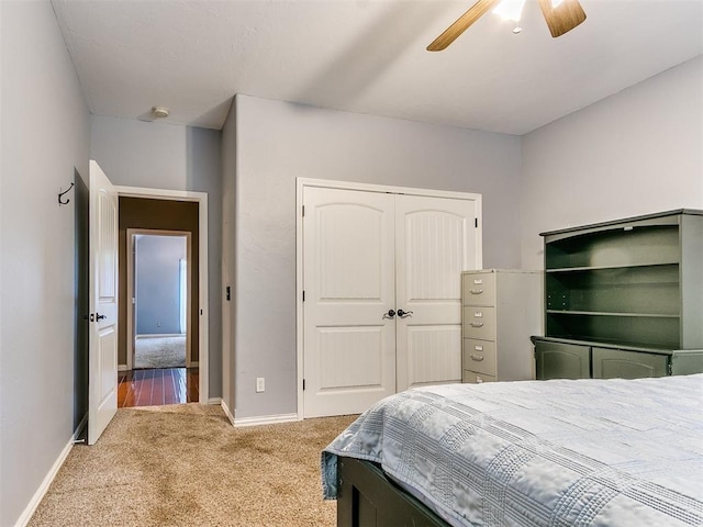 carpeted bedroom featuring ceiling fan and a closet