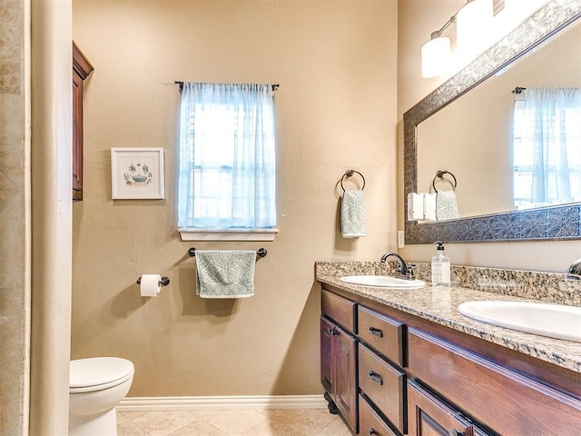 bathroom with tile patterned flooring, vanity, and toilet