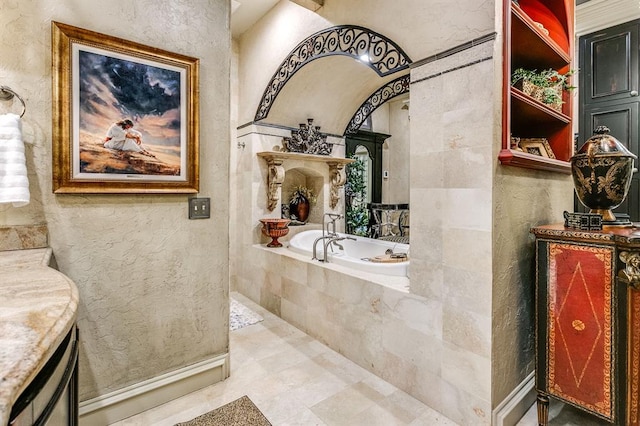 bathroom featuring vanity and tiled tub