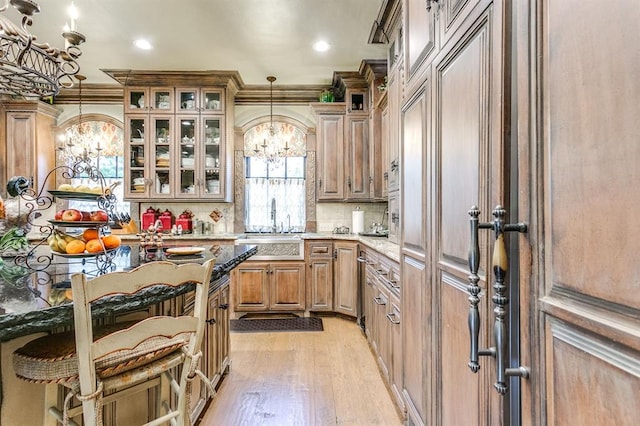 kitchen featuring pendant lighting, backsplash, light hardwood / wood-style flooring, and ornamental molding