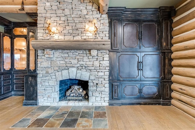 room details featuring a stone fireplace and log walls