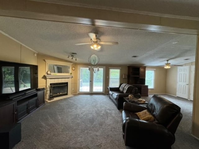 carpeted living room with ceiling fan, a fireplace, crown molding, and a textured ceiling