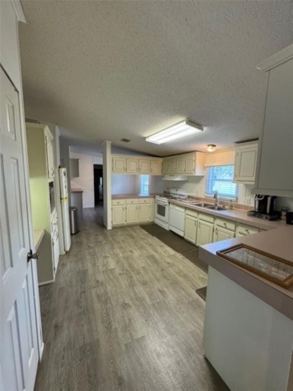 kitchen featuring white appliances, sink, light wood-type flooring, a textured ceiling, and extractor fan