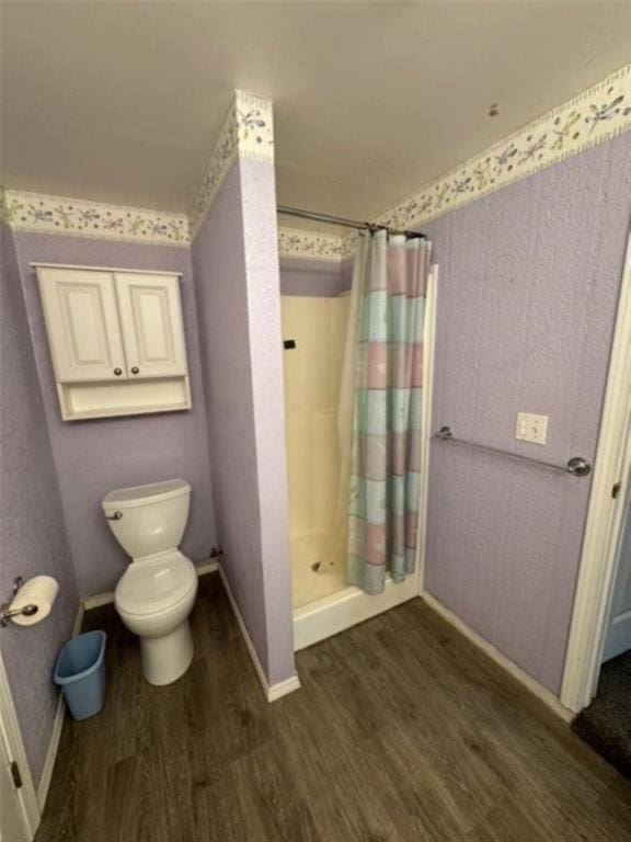 bathroom with a shower with curtain, hardwood / wood-style floors, and toilet