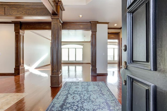 entryway with decorative columns, beamed ceiling, wood-type flooring, and ornamental molding