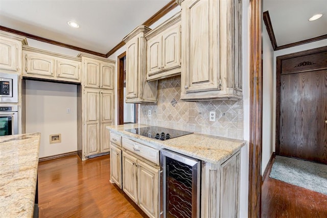 kitchen with wine cooler, hardwood / wood-style flooring, ornamental molding, appliances with stainless steel finishes, and light stone counters