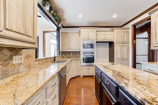 kitchen featuring light stone countertops, sink, stainless steel appliances, ornamental molding, and hardwood / wood-style flooring