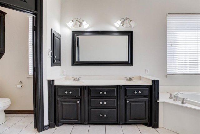 bathroom featuring tile patterned floors, vanity, toilet, and a tub to relax in