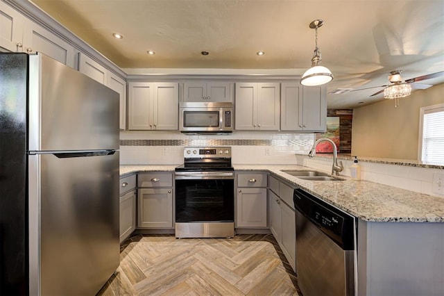 kitchen with kitchen peninsula, appliances with stainless steel finishes, tasteful backsplash, light parquet floors, and sink