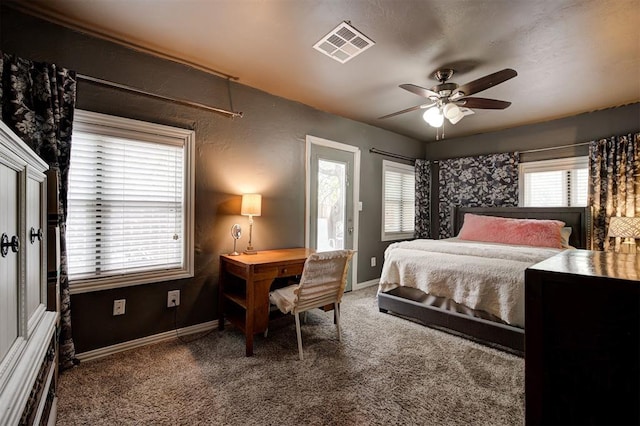 carpeted bedroom featuring multiple windows and ceiling fan