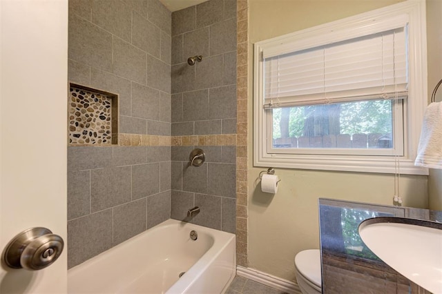 full bathroom with vanity, tiled shower / bath, and toilet