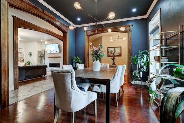 dining area with hardwood / wood-style floors, a notable chandelier, and ornamental molding