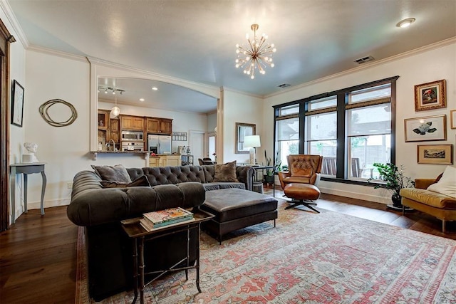 living room with a chandelier, dark hardwood / wood-style flooring, and ornamental molding