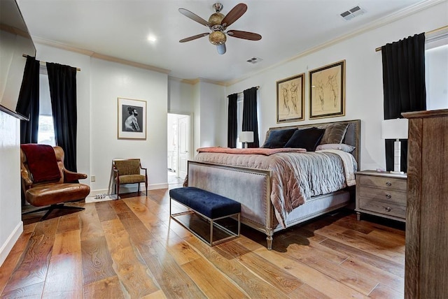 bedroom with ceiling fan, crown molding, and light hardwood / wood-style floors