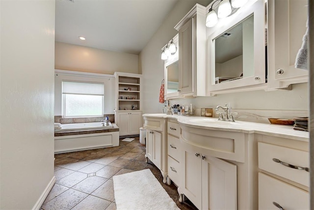 bathroom with tile patterned flooring, vanity, and a bath