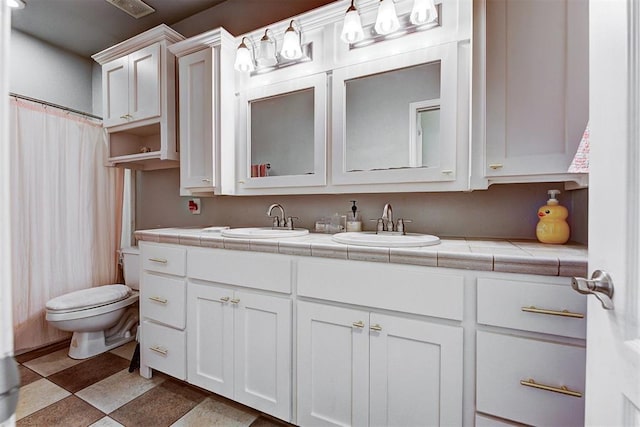 interior space with vanity, a shower with shower curtain, and toilet