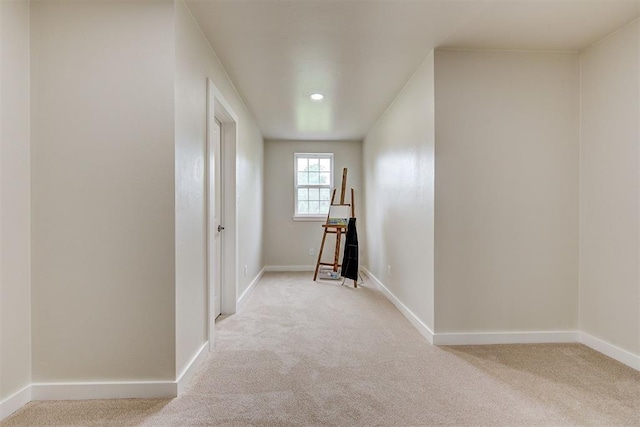 hallway featuring light colored carpet